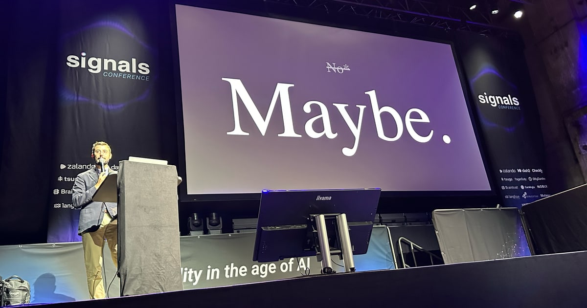 Спикер на Signals Berlin у слайда, где «No» зачёркнуто и крупно написано «Maybe»