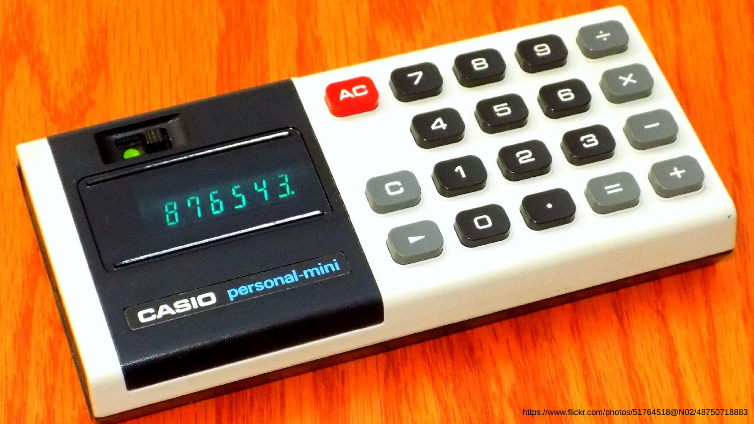 A 1970s Casio personal-mini pocket calculator on a wooden desk