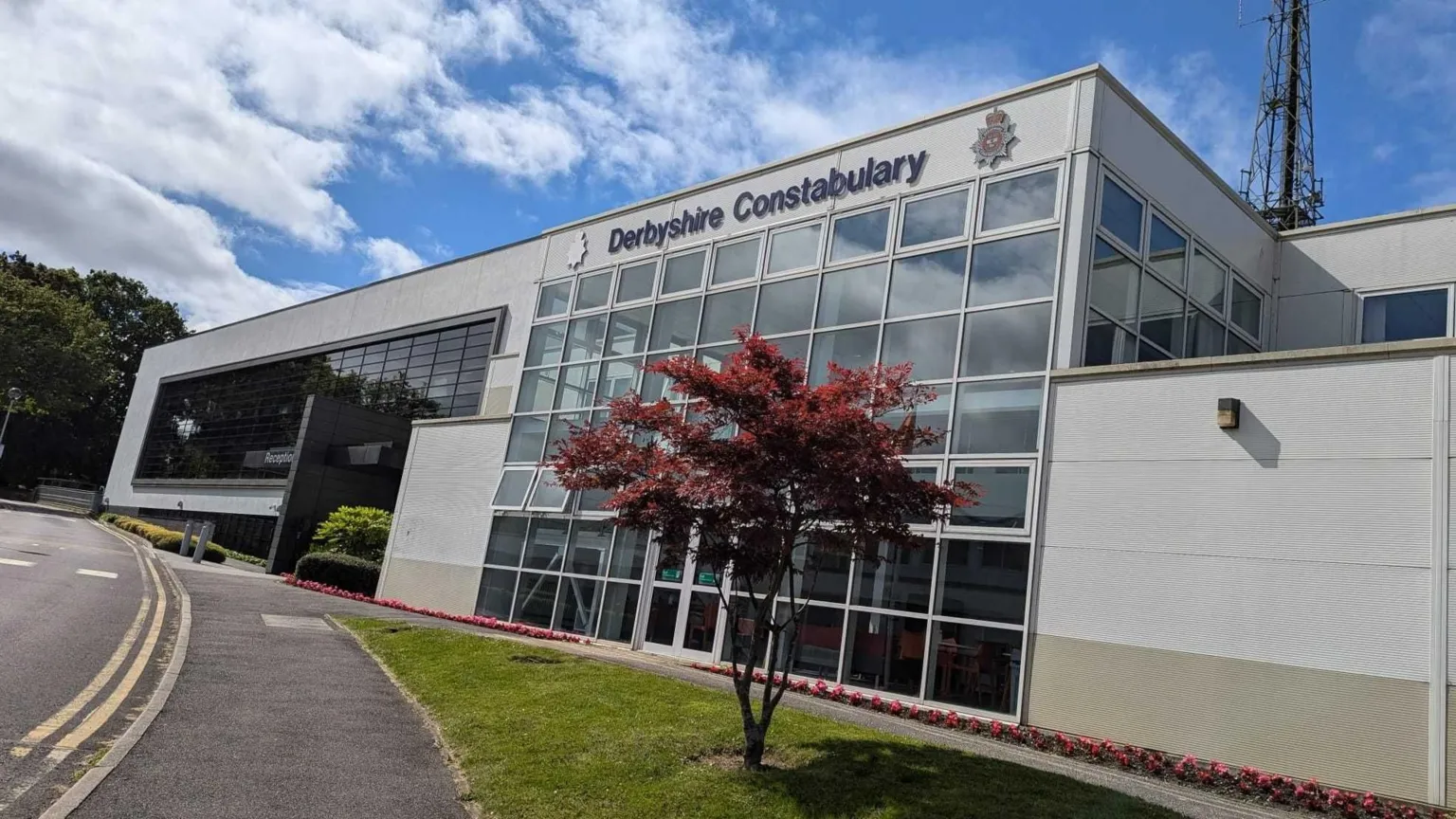 BBC Derbyshire Police headquarters, which is a grey building with glass windows.